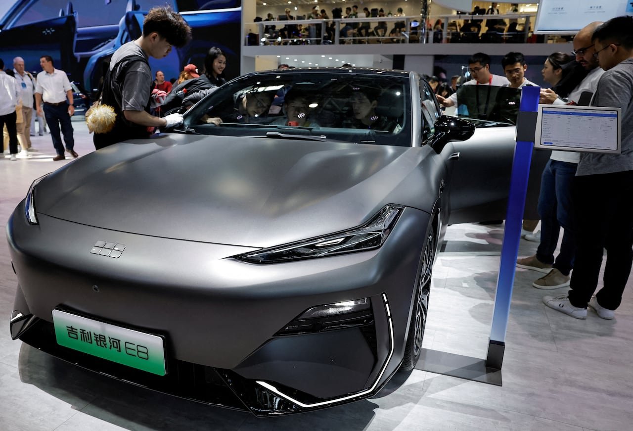 A staff member cleans the Geely Galaxy E8 electric vehicle at the Beijing International Automotive Exhibition, or Auto China 2024, in Beijing, China.