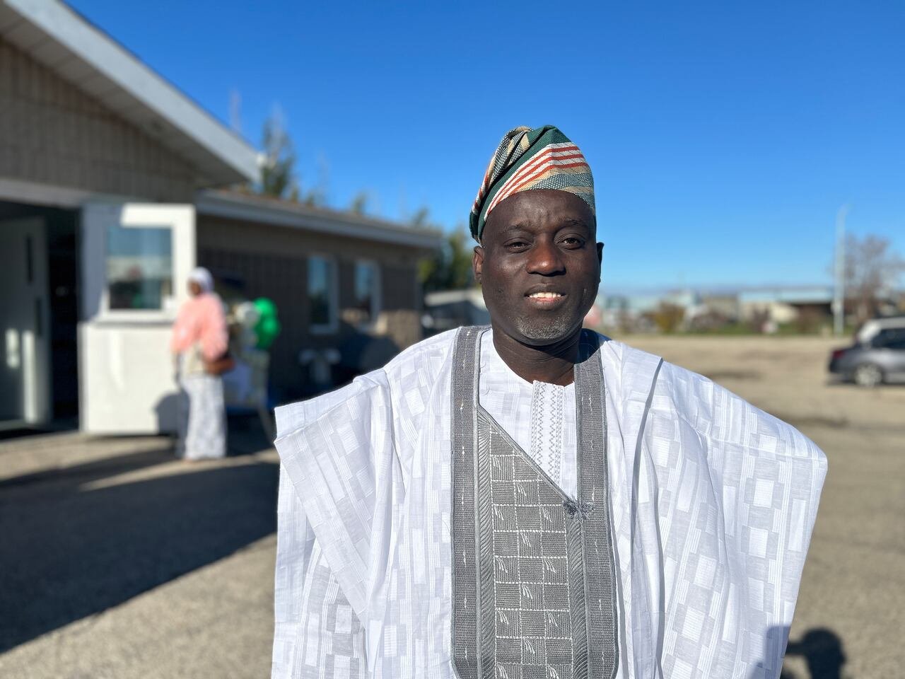An individual in distinctive attire, donning a colorful hat